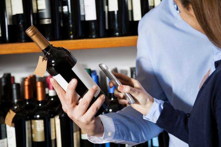 Hombre y mujer escanean un código QR de una botella de vino